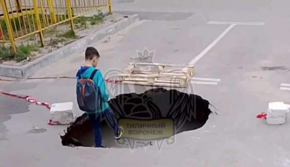 Асфальт провалился в заполненную водой яму на воронежской парковке